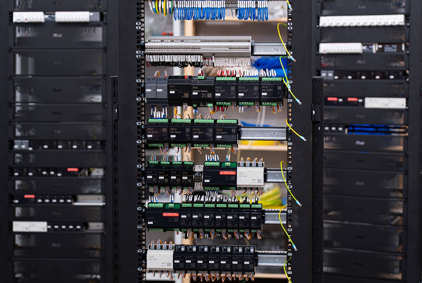 Interior de quadro de automação com módulos em trilho DIN, bornes e chicotes de cabos organizados