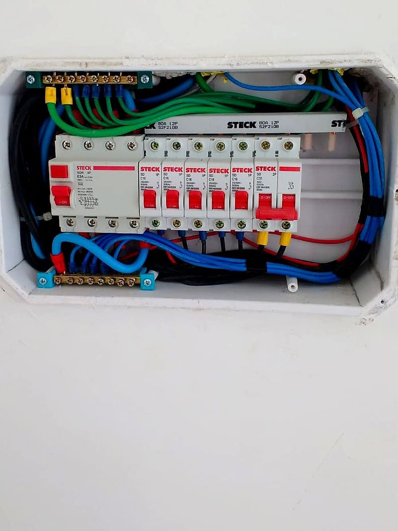 Quadro de distribuição residencial com disjuntor diferencial residual de 63 A, disjuntores em trilho DIN, barramentos de neutro e terra separados e cabos identificados por cor